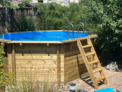 Interline Bali rond 440 x 136 cm tussen het groen met RVS trap bij een klant